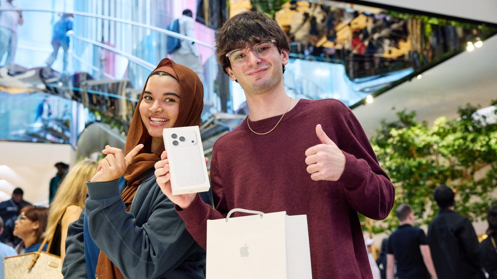 Hai khách hàng cầm hộp iPhone 18 Pro vừa mua trong ngày mở bán tại cửa hàng Apple
